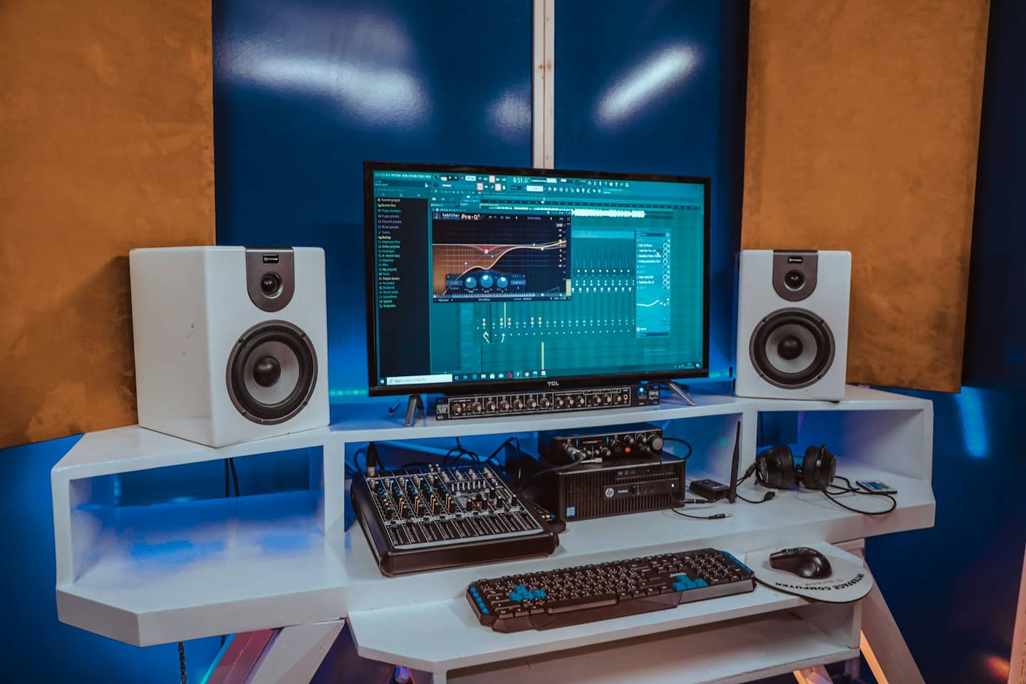 Modernt hemmastudio med dator, högtalare och mixer.
